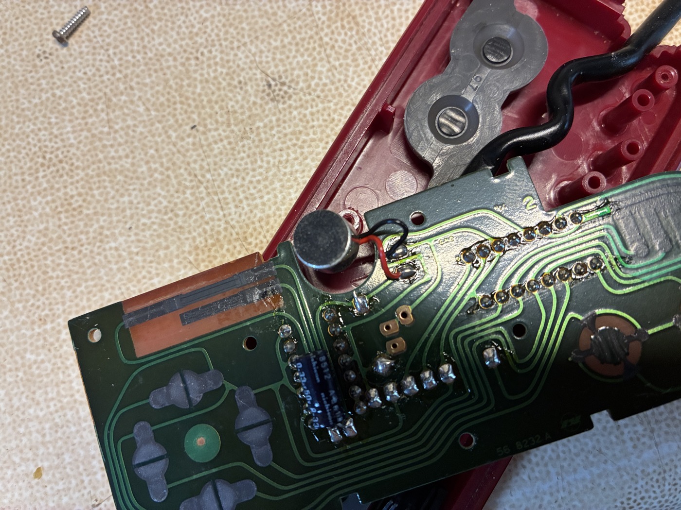 The Player-2 controller opened, showing the microphone, its two lead wires, and the volume slide switch